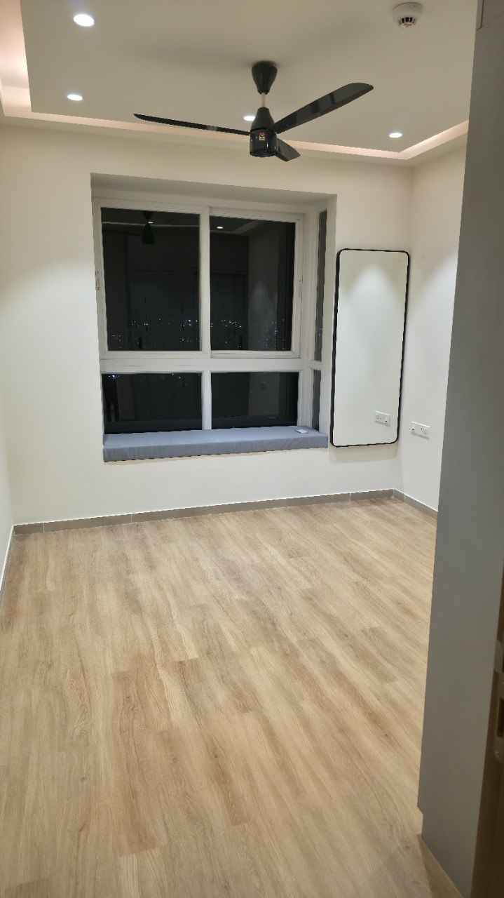 Bedroom with window bay seat, oak-tone flooring and cove ceiling